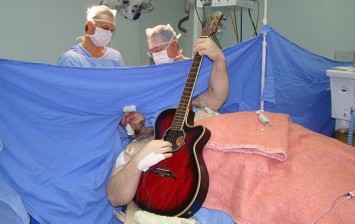 man plays Beatles guitar BRAIN SURGERY