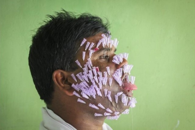 هندي يغرز مئات الابر في وجهه