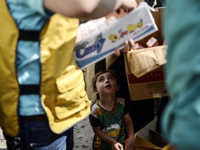 طفل سوري ينتظر الحصول على مؤونة غذائية بالقرب من مركز حدودي في محافظة سانليورفا التركية.