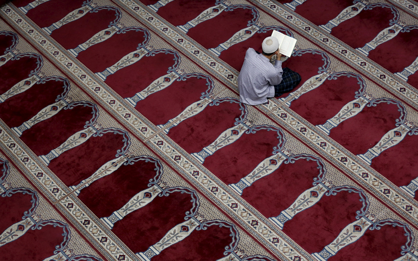 رجل مسلم يقرأ القرآن الكريم داخل مسجد في جاكرتا