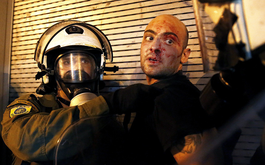 القبض على محتج من قبل شرطة مكافحة الشغب في اشتباكات أثينا.