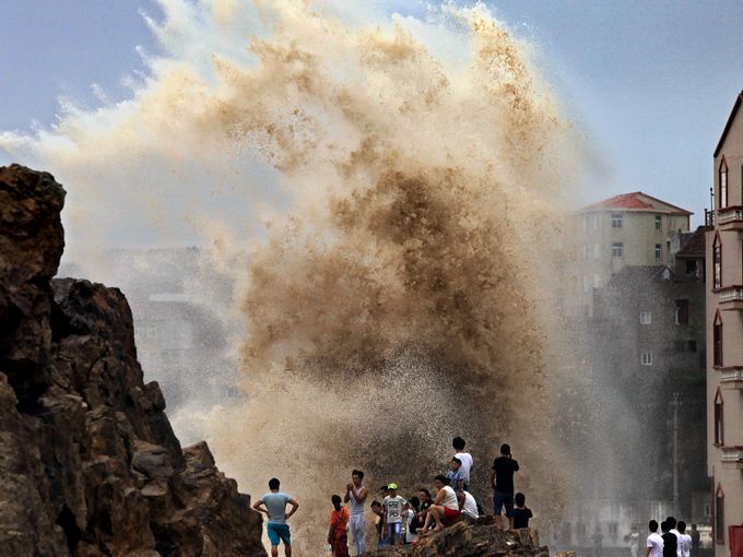 سكان يتجمعون لمراقبة موجات ضخمة وصلت إلى مقاطعة تشجيانغ